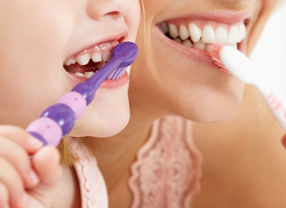 Mother and Daughter Brushing Teeth